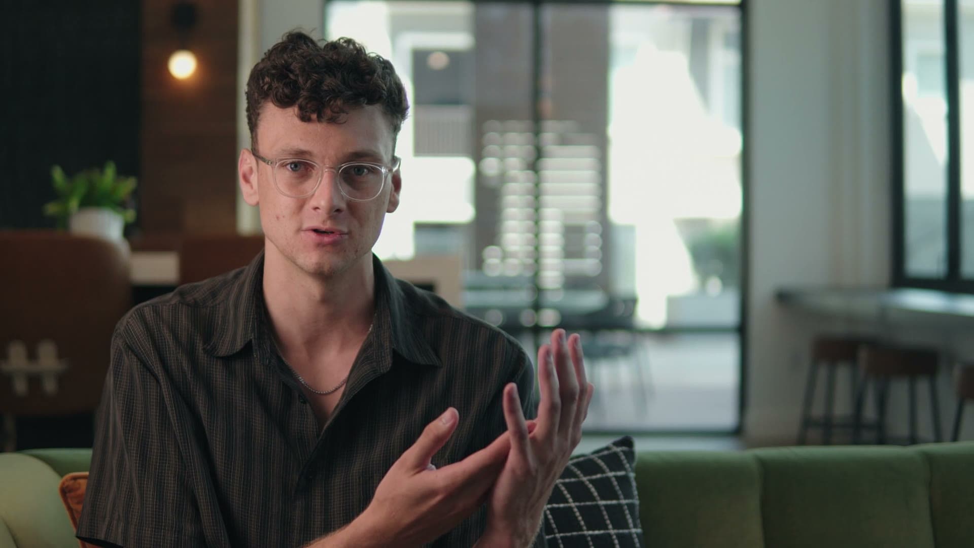 Pauv's founder in glasses talking with his hands on a sofa in a bright office