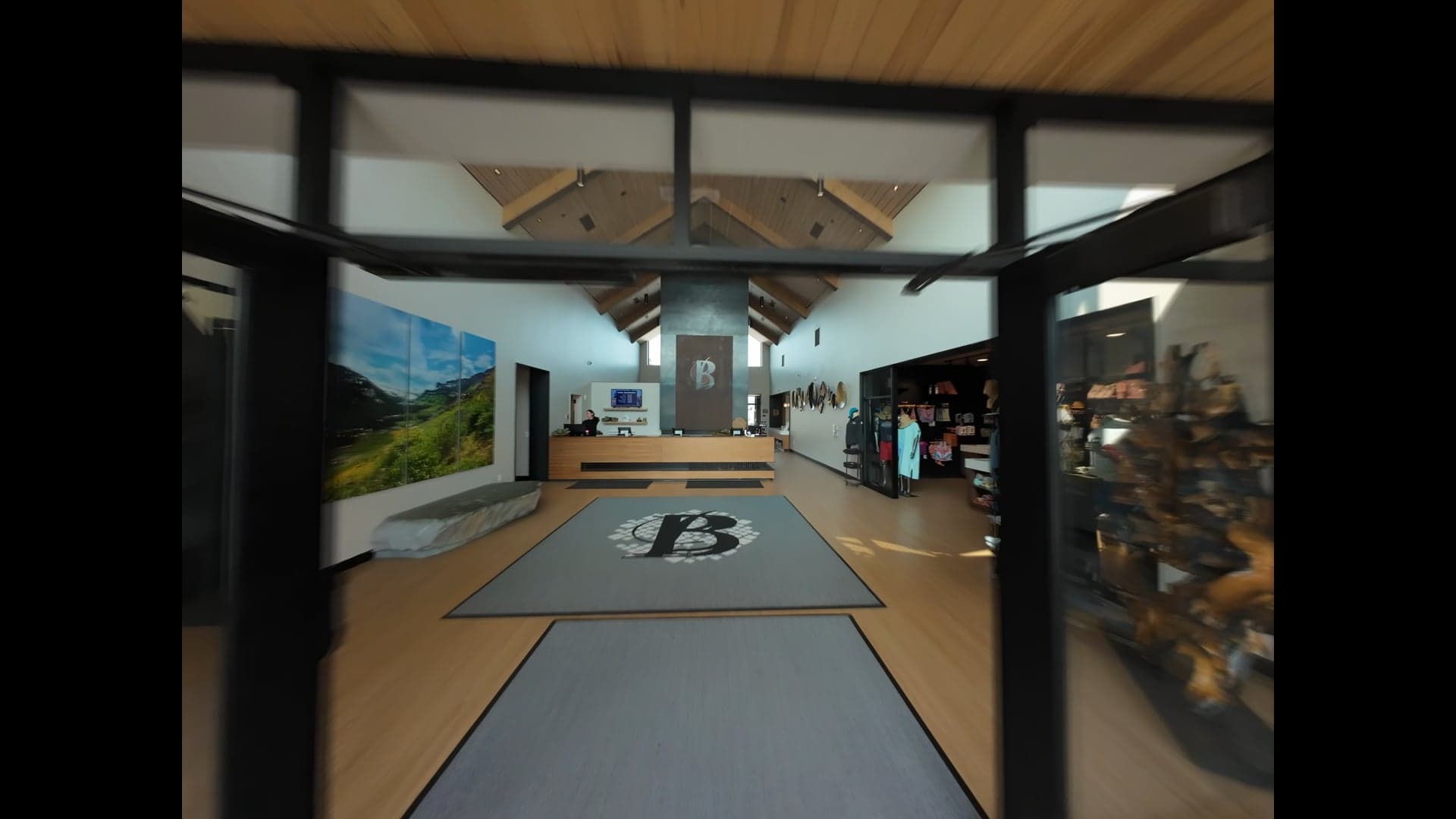 Timber-framed lobby at Bozeman Hot Springs, looking through the entry doors to the front desk and retail shelves