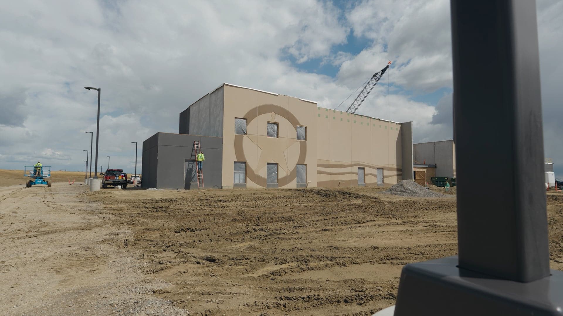 Dick Anderson's aviation facility going up on a bare Billings site with a crawler crane at the corner