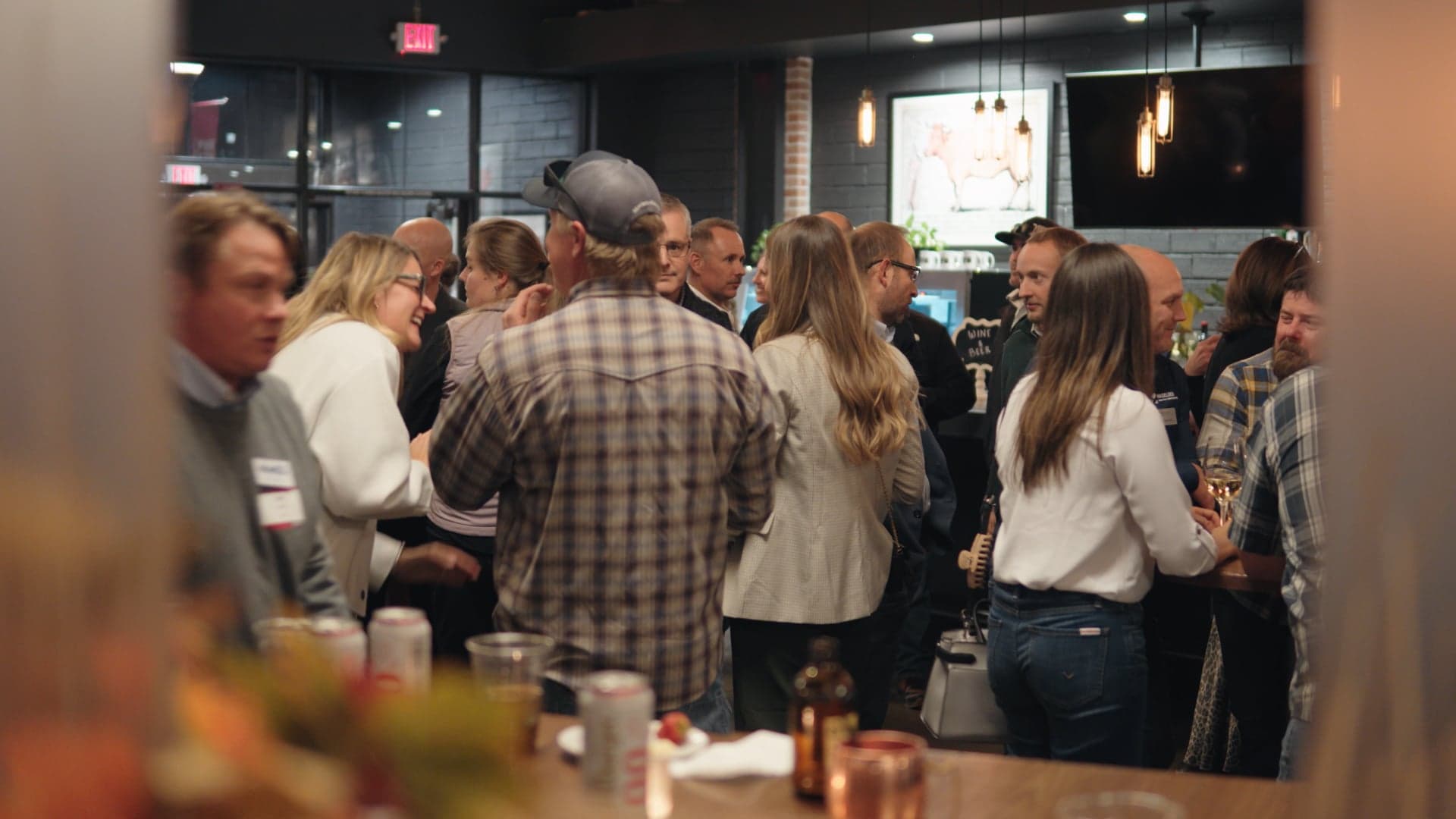 Guests standing with drinks in a crowded room at the Haselden open house in Bozeman